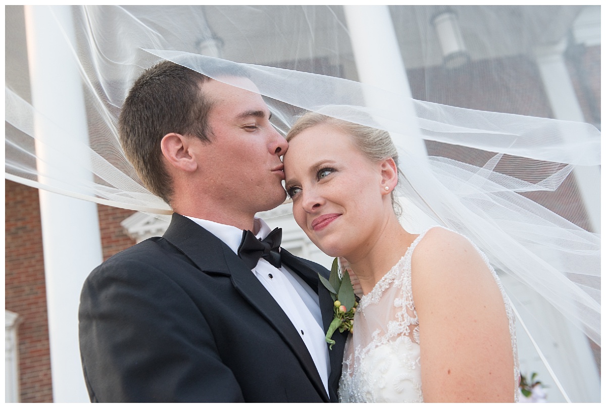 Groom kissing bride's forehead in a sweet portrait